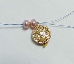 Two beads and a clasp strung onto a thread
